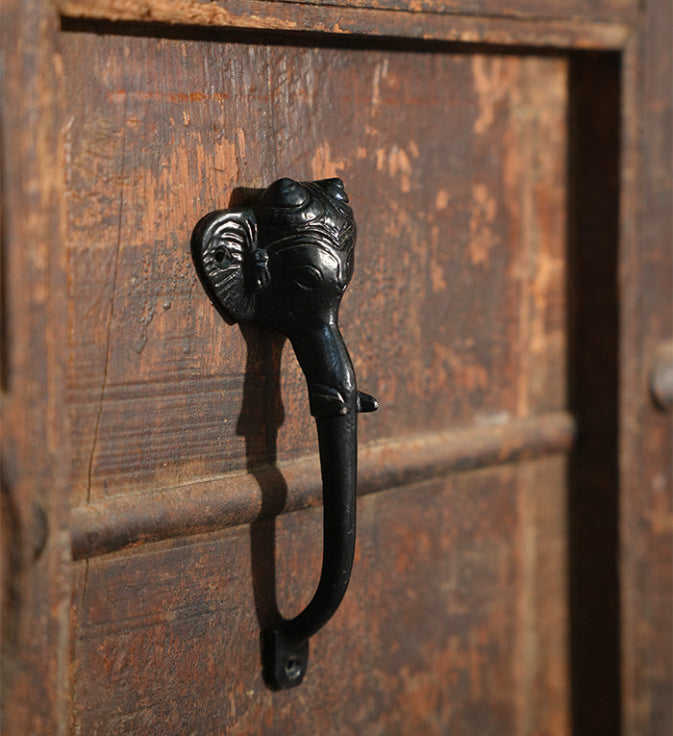 Decorative black metal handle on a wooden door
