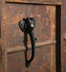 Decorative black metal handle on a wooden door