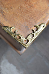 Decorative brass corner bracket on a wooden surface