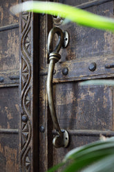 Decorative iron metal handle on an aged wooden door
