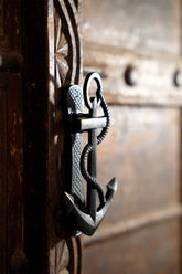Decorative metal anchor knocker on a wooden door