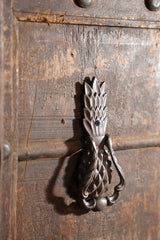 Decorative pineapple metal door knocker on a wooden door