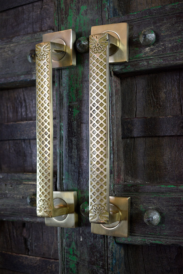 Decorative brass door handles on a wooden door