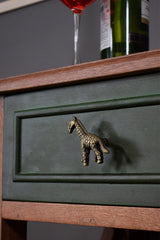 Green drawer with a giraffe-shaped handle, wine glass, and bottle in the background.