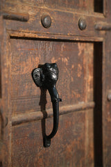 Decorative black metal handle on a wooden door